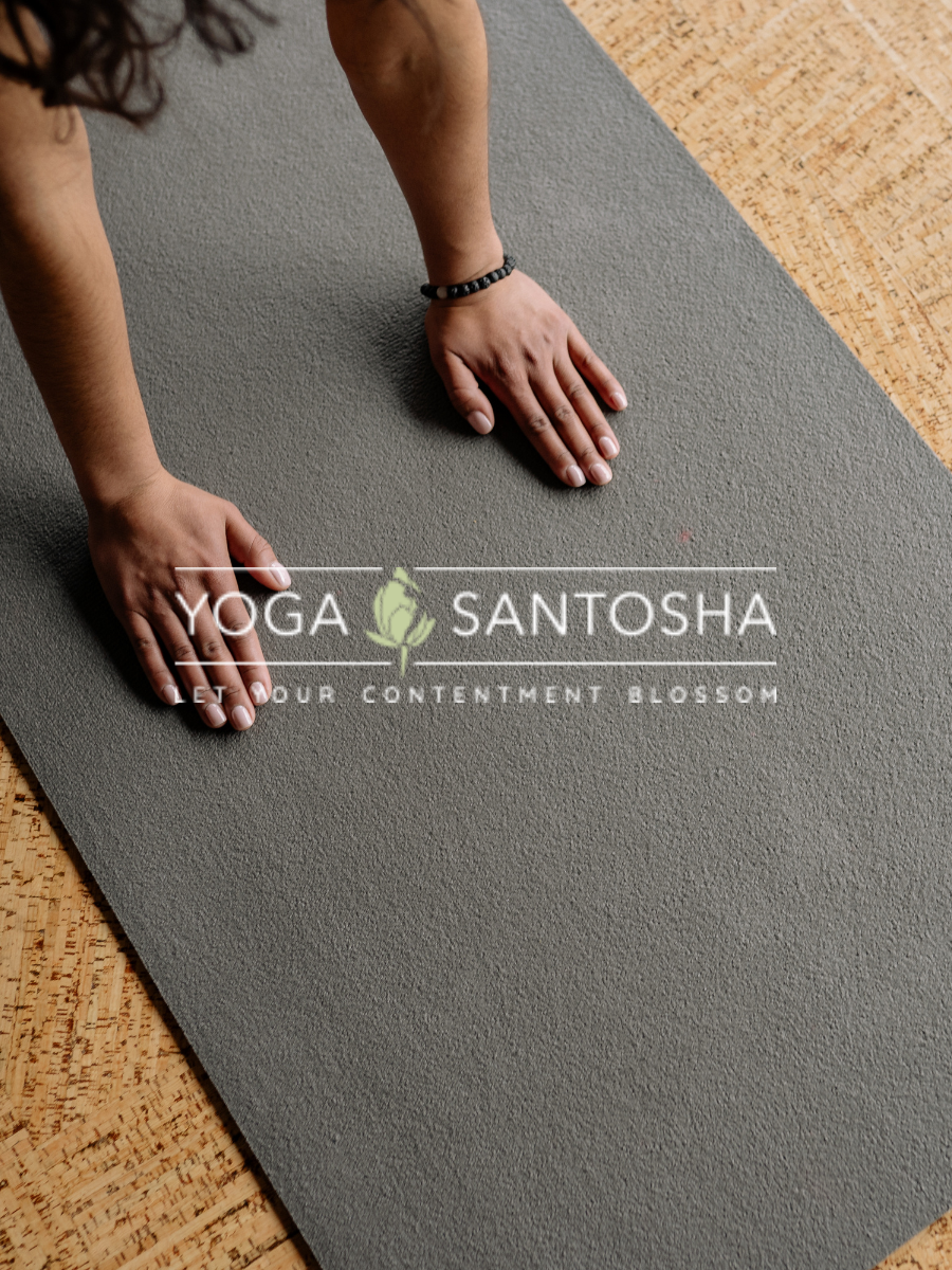 Yoga Santosha logo on background of yoga matt